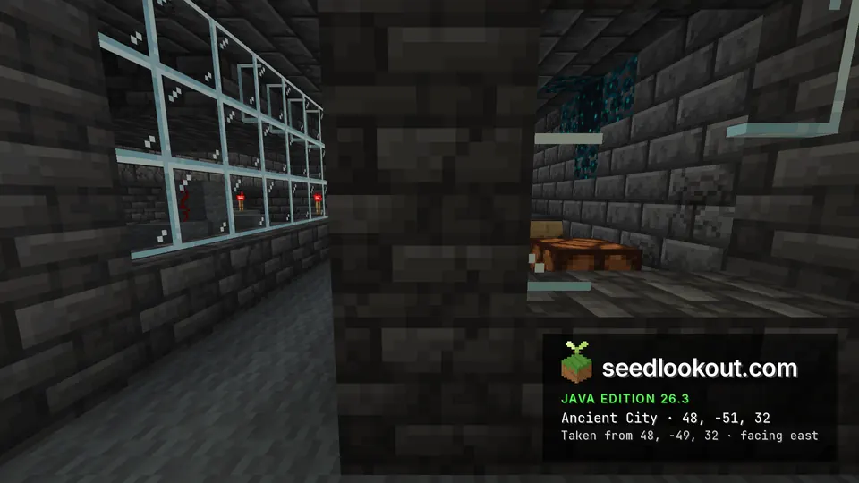 Deepslate pillar beside a long glass window in the ancient city, redstone torches beyond
