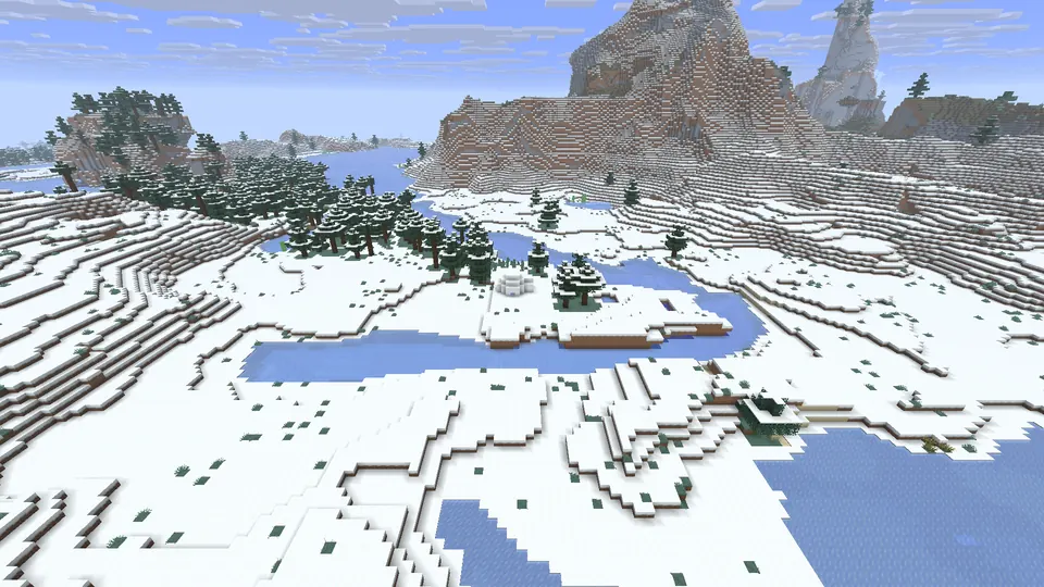 Small snow igloo on a bank beside a frozen stream, spruce trees and a rocky hill behind