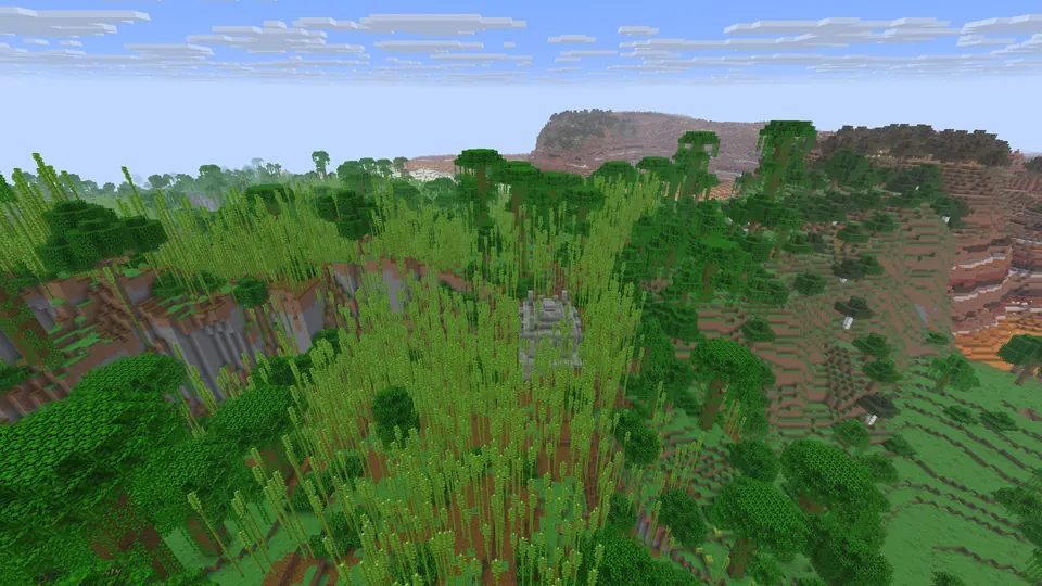 Grey stone temple in tall bamboo and jungle trees on a hill, a red badlands mesa behind