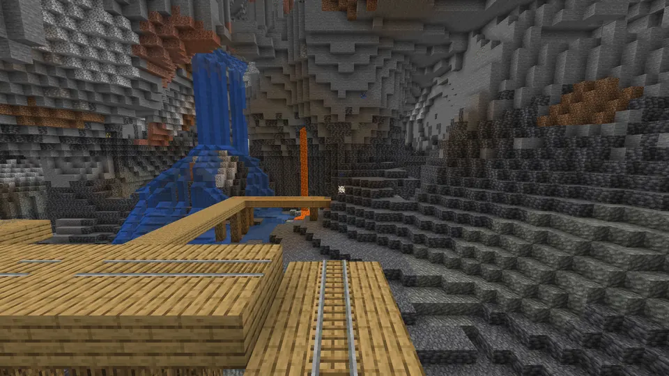 Mineshaft plank bridge with rails in a large deepslate cave with a waterfall and a lava fall
