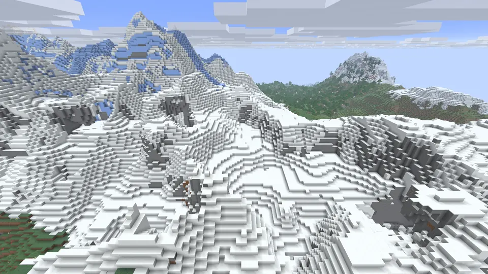 Snow-covered mountain slopes and grey cliffs with blue ice on a peak, a green hill to the right