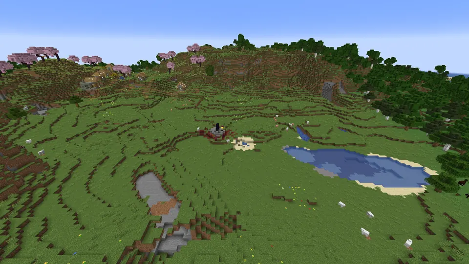 Small ruined portal with netherrack in a grassy meadow beside a pond, the village on the hill behind