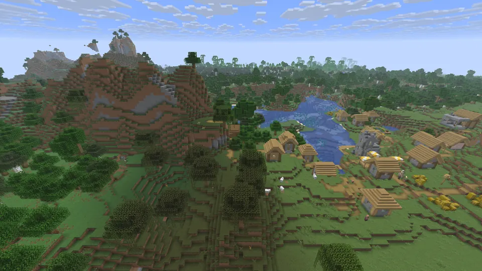 Plains village houses beside a blue lake, with a steep brown hill and dark trees on the left
